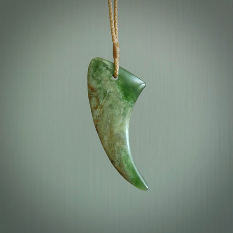 This is a lovely New Zealand Jade, pounamu drop pendant. Hand carved for us by Ric Moor. It is bound with an adjustable beige coloured cord which is length adjustable. Free worldwide shipping.