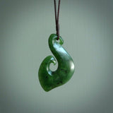 This picture shows a jade hook pendant, also called a hei-matau, carved for us in New Zealand jade. The carver is Ric Moor - and this is a beautiful example of his work. The cord is a four-plait, adjustable brown coloured necklace.