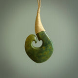 This matau, with koru, is carved from a very striking New Zealand jade. It is both intricate and simple in design - it has hidden folds and smooth curves. A piece to be worn or displayed - the carving and the jade are both magnificent. Hand made by Donna Summers.
