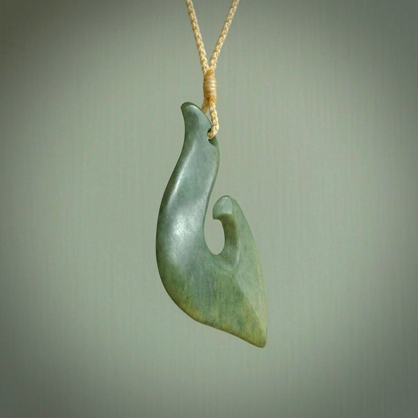 This matau, is a large pendant hand carved from New Zealand jade. It is both intricate and contemporary in design - it has hidden folds and smooth curves. A piece to be worn, the carving and the jade are both magnificent. A large hand carved New Zealand Jade hook by artist Ric Moor.