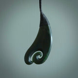 A hand carved large sized drop pendant with a koru carved into the front face. This is a piece of genuine jade jewellery, hand carved by Ric Moor. He has used New Zealand jade and has utilised his experience and carving skill to highlight the natural beauty of the stone. Delivered worldwide, postage is included in the price.