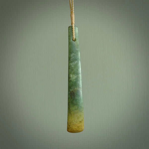This is a lovely, large, New Zealand Flower Jade, pounamu drop pendant. Hand carved for us by Ric Moor. It is bound with an adjustable beige coloured cord which is length adjustable. Free worldwide shipping. The light reveals the internal structure and colour of the stone beautifully.