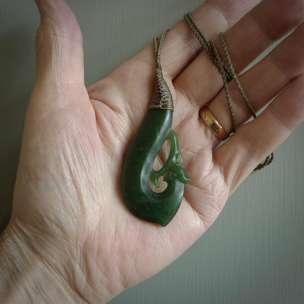 This picture shows a contemporary manaia pendant carved for us by Ric Moor. It is a deep green colour in traditional manaia design. We have plaited a cord in olive and made it length adjustable. This is a very beautiful piece of art to wear.