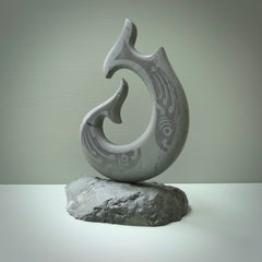 Hand carved large New Zealand Argillite Stone Matau, hook carving displayed in a New Zealand Pākohe stand sculpture. Hand carved here in New Zealand by Kerry Thompson. This is a 'one only' sculpture, a beautiful display piece.