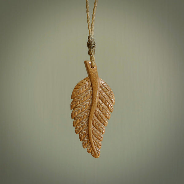 Hand carved woolly mammoth tusk fern pendant. Made in New Zealand. Unique hand made gifts from NZ Pacific. Hand carved fern necklace from ancient woolly mammoth tusk.