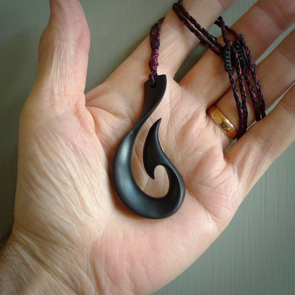 A hand carved large Black Jade Hook, Matau, necklace. The cord is a black colour and is a fixed length. A large sized hand made hook necklace by New Zealand artist Kerry Thompson. One off work of art to wear.