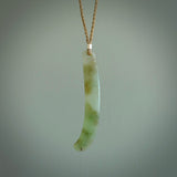 This picture shows a hand carved Spoon River White Jade drop pendant with adjustable cord. The jade is a very light, white green with a shimmer of darker tones in the stone. It is suspended from a tan coloured cord. Delivery is free worldwide.