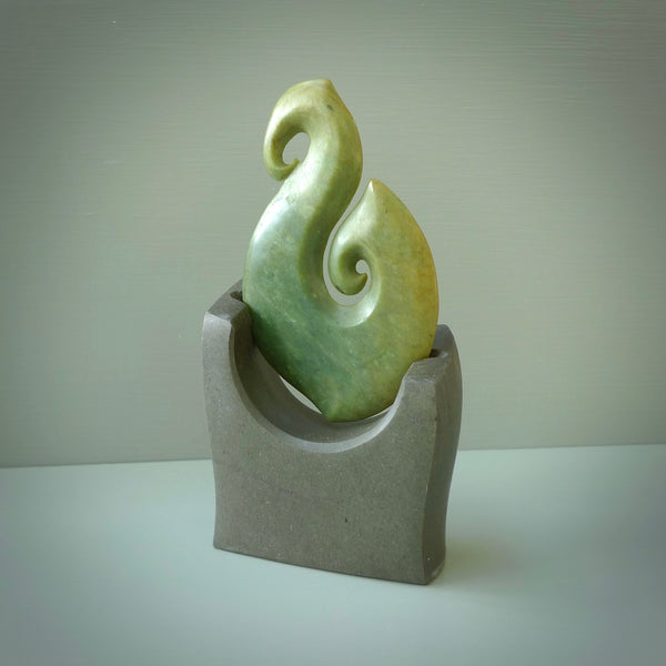 Hand carved New Zealand Flower Jade Hook with Greywacke stand sculpture. Hand carved in New Zealand by Ric Moor. This is a one only sculpture and is a beautiful, large, display piece.