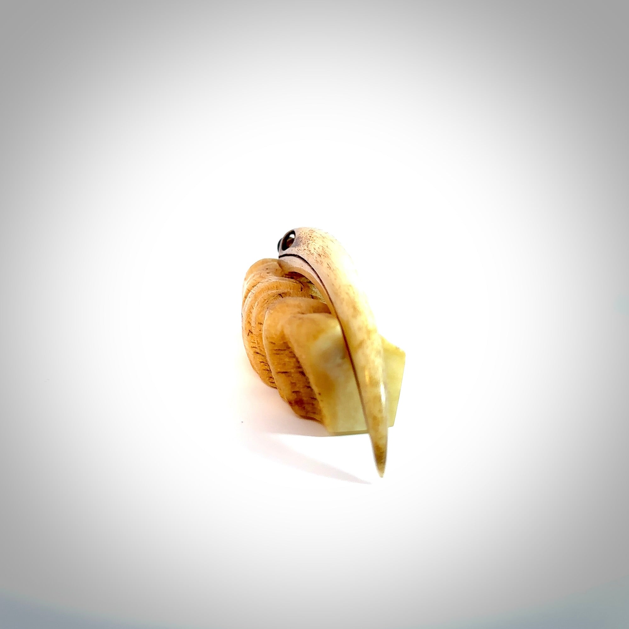 This is a hand carved rams horn huia bird beak pendant. It is made from rams horn with 24 carat gold leaf and jade toggle. This is a large sized necklace and is a very unique, one only, pendant that is a collectors piece. Hand carved by New Zealand artist, Sami.