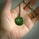Hand carved New Zealand jade koru pendant. Delivered to you on a hand plaited manuka green cord which is adjustable. Free delivery worldwide.