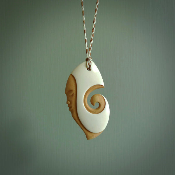 A hand carved bone contemporary, intricate pendant. The cord is ice white/gingernut and is an adjustable length. A large sized hand made contemporary necklace by New Zealand artist Kerry Thompson. Kerry has stained parts of the bone which really add to the dimension of this pendant. One off work of art to wear.