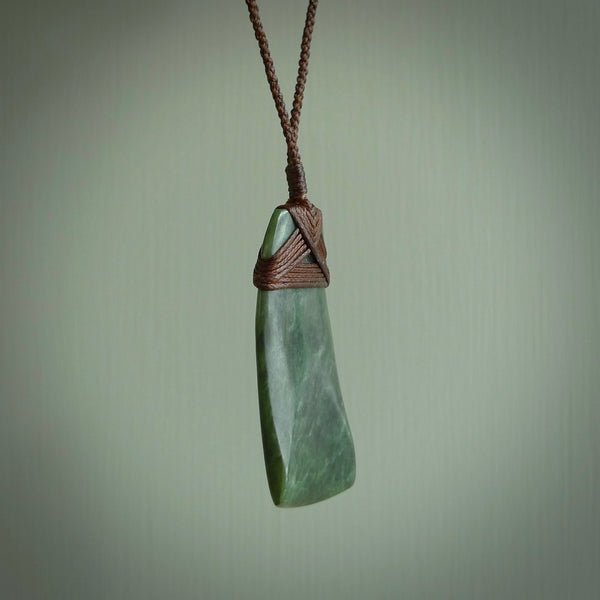 Hand carved from a lovely piece of local New Zealand Jade. The quality of the workmanship and design is outstanding - this is a piece you will want to wear all the time. We have suspended this from a 3-plait brown cord which can be adjusted with a couple of slip knots and brown binding.