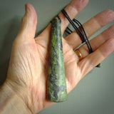 This photo shows a large jade drop shaped pendant. It a a lovely, colourful douglas creek jade. The cord is a four plait black and is adjustable in length. One only large, contemporary drop necklace from Jade, by Rueben Tipene.