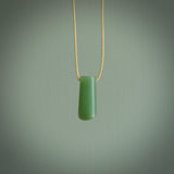 This picture shows a small hand carved jade drop pendant by Ric Moor. The jade is a wonderful light, semi-translucent, green. It is suspended from a beige adjustable cord. Delivery is free worldwide.