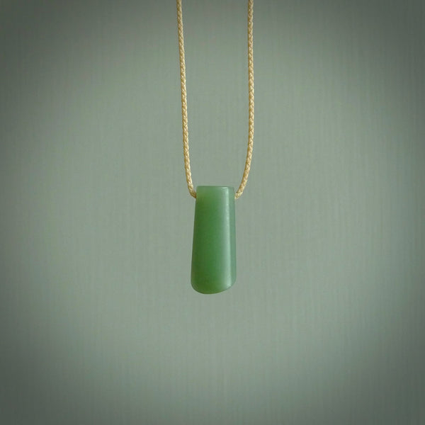 This picture shows a small hand carved jade drop pendant by Ric Moor. The jade is a wonderful light, semi-translucent, green. It is suspended from a beige adjustable cord. Delivery is free worldwide.