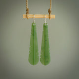 This picture shows New Zealand Pounamu, jade feather earrings with sterling silver hooks. Hand made unique and contemporary feather earrings by Kerry Thompson. Hand carved here in New Zealand from New Zealand Jade. One pair only.