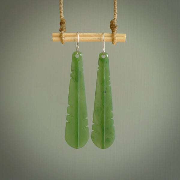This picture shows New Zealand Pounamu, jade feather earrings with sterling silver hooks. Hand made unique and contemporary feather earrings by Kerry Thompson. Hand carved here in New Zealand from New Zealand Jade. One pair only.