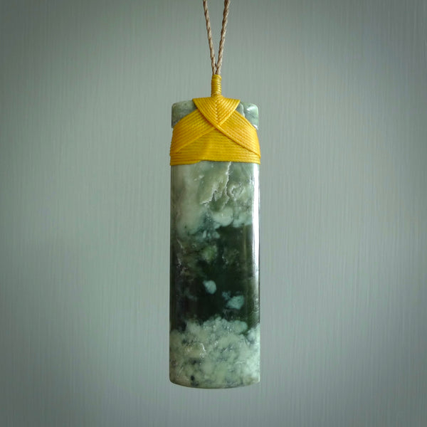 A large and beautiful hand carved toki pendant. This piece is carved from New Zealand flower jade by NZ Pacific. This is a wonderful large toki bound with a tan cord and a traditional lashing. A beautiful, traditional toki for sale online.