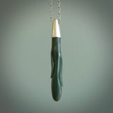 This picture shows a hand carved Inanga Pounamu, jade drop pendant with sterling silver cap and chain. The jade is a very dark green with a shimmer of light blue tones in the stone. It is suspended from a sterling silver clasp and we supply a sterling silver chain. Delivery is free worldwide.