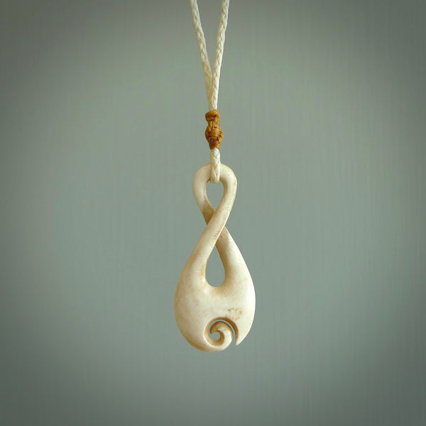 Hand carved Single twist pendant with a little koru carved into the bottom. This pendant is carved from a lovely cream coloured bone. The artist is Yuri Terenyi. Bone art to wear by NZ Pacific.