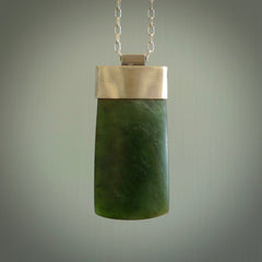 This picture shows a hand carved jade toki, drop pendant with sterling silver cap and chain. The jade is a very dark green with a shimmer in the stone. It is suspended from a sterling silver clasp and we supply a sterling silver chain. Delivery is free worldwide.