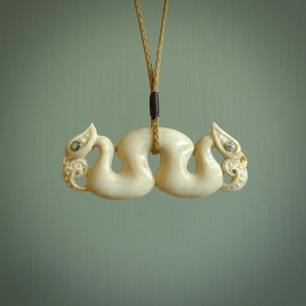 This is a unique double manaia, pekapeka, handcarved bone pendant from deer antler . The cord is Kalahari and is length adjustable. This is delivered to you with Express Courier. The eyes are made from Paua shell.