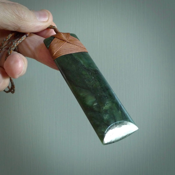 This is a lovely, one-off large, green toki pendant we've made from a gorgeous New Zealand jade. It is finished in a polished sheen and is bound with our plaited cord. These are wonderful pieces that are very attractive and will last a lifetime.