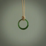 This piece is a oval round, ring pendant. It was carved for us by Ric Moor from a lovely light and milky green piece of New Zealand jade. It is suspended on a beige coloured braided cord that is length adjustable.