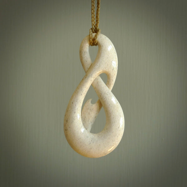 A hand carved intricate and complex woven design pendant from Whale Bone. The cord is tan and adjustable in length. Large hand made woven necklace by New Zealand artist Kerry Thompson.