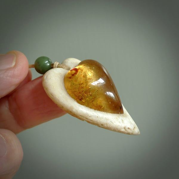 This is a hand carved whalebone heart with amber pendant. It is made from whale bone. This is a medium sized necklace and is a very unique, one only, pendant that is a collectors piece. Hand carved by New Zealand artist, Sami.