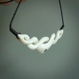 A hand carved twist pendant made from bone. This is a work of art carved by Fumio Noguchi who is renowned for his skill in bone carving. We deliver this pendant to you on a plaited black cord. Delivery with Express Courier is included in the price.