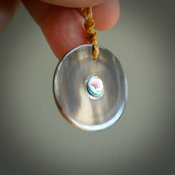 Hand carved natural bone with buffalo horn contemporary disc pendant with creative and unique carvings on the front face of each individual piece. Delivered with an adjustable cord.