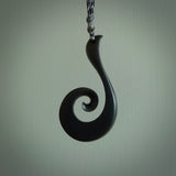 A hand carved large sized Black Jade Koru necklace. The cord is a tan colour and is a fixed length . A large sized hand made hook necklace by New Zealand artist Kerry Thompson. One off work of art to wear.