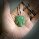 This picture shows a tiger pendant that we designed in Jade stone with Amber inlay eyes. It is a tiger head that is carved in detail. A really attractive and eye-catching piece of handmade jewellery. The cord is hand plaited braid in green and the length can be adjusted.