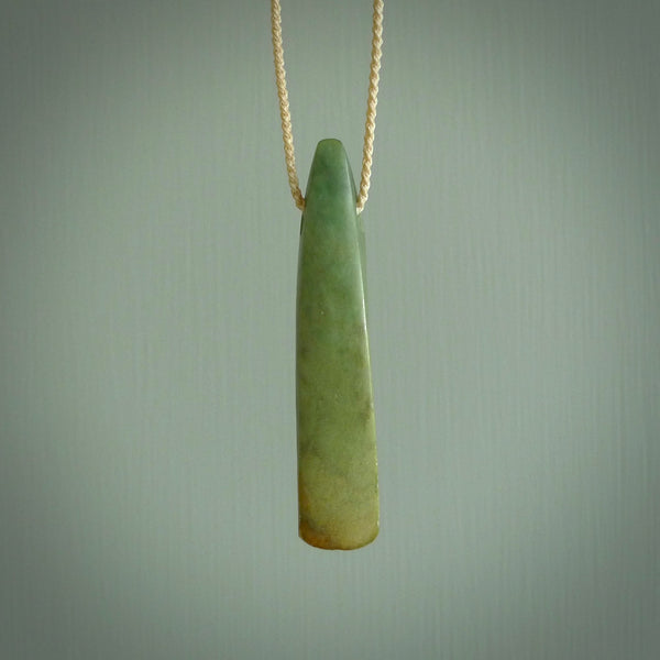 This is a lovely, large, New Zealand Flower Jade, pounamu drop pendant. Hand carved for us by Ric Moor. It is bound with an adjustable beige coloured cord which is length adjustable. Free worldwide shipping. The light reveals the internal structure and colour of the stone beautifully.