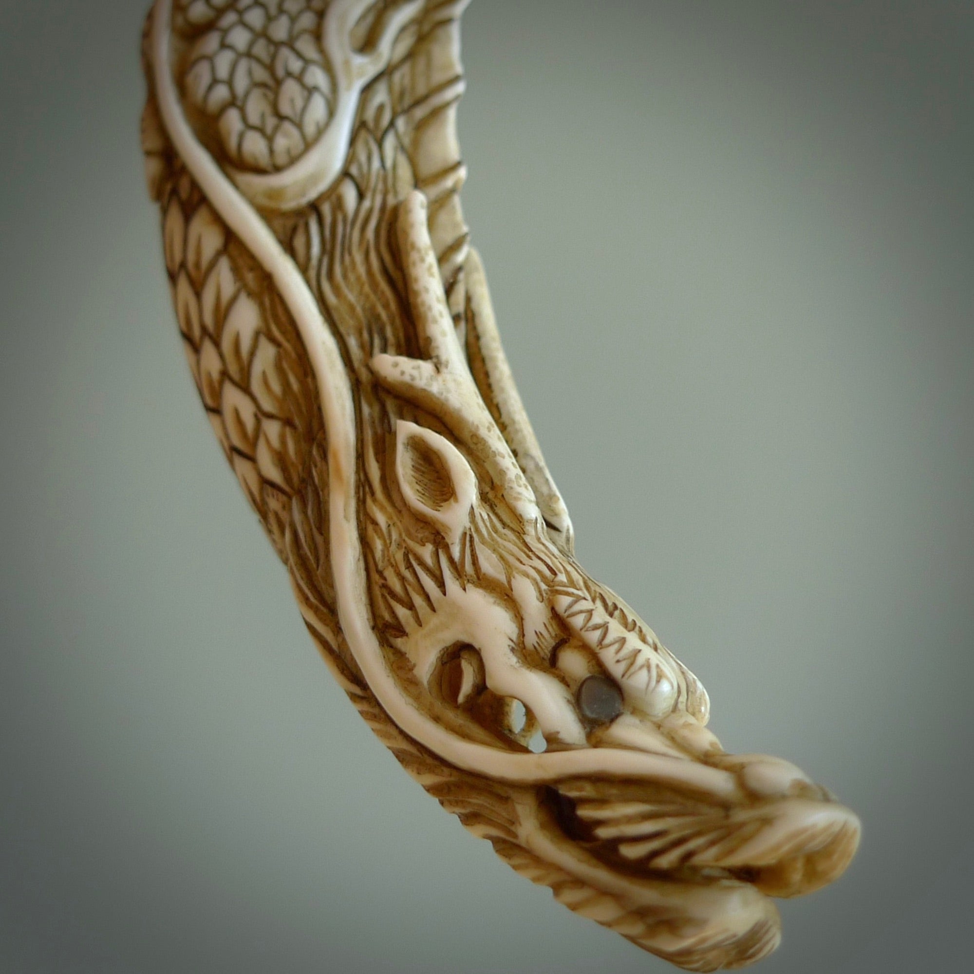 Hand carved dragon Pendant. Made from warthog tusk in New Zealand. Unique dragon necklace hand made from warthog tusk by master bone carver Fumio Noguchi. Spectacular collectable work of art, made to wear. One only pendant, delivered to you at no extra cost with express courier.