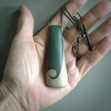 This photo shows a large jade drop shaped pendant. It a a lovely, colourful Inanga jade. The cord is a green colour and is adjustable in length. One only large, contemporary drop necklace from Jade, by Rueben Tipene.