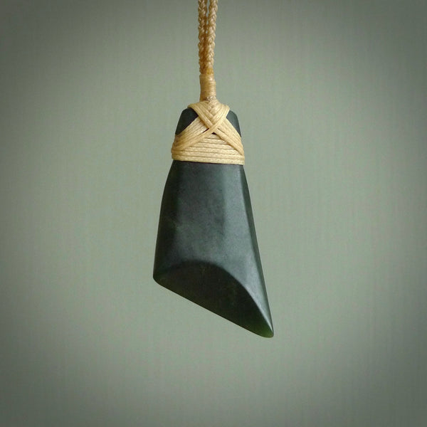 Hand carved from a lovely piece of local New Zealand Jade. The quality of the workmanship and design is outstanding - this is a piece you will want to wear all the time. We have suspended this from a 3-plait beige cord which can be adjusted with a couple of slip knots and beige binding.