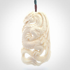 This is a hand carved bone dragon pendant. It is made from bone and has an adjustable Plum coloured cord. This is a large sized necklace and is a very unique, one only, pendant that is a piece for art lovers.