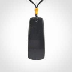 Black Jade toki pendant with bone flower. We've bound it with an adjustable black cord and yellow floret.