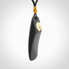 Black Jade toki pendant with bone flower. We've bound it with an adjustable black cord and yellow floret.