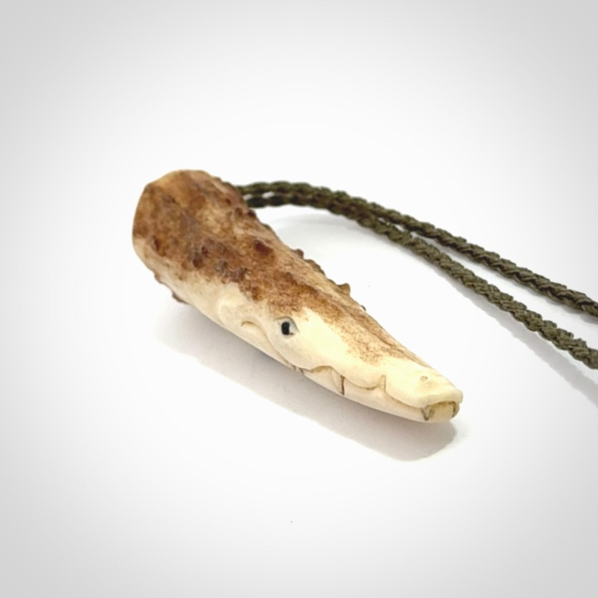 A hand carved crocodile pendant carved from a piece of deer antler. This is a work of art carved by Fumio Noguchi who is renowned for his skill in bone carving.
