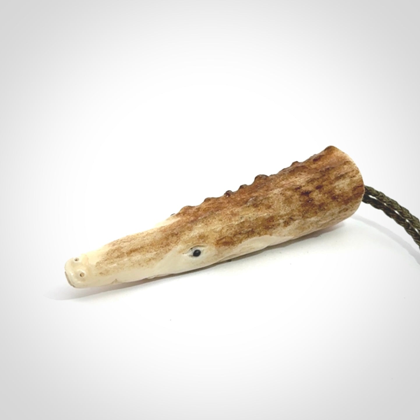 A hand carved crocodile pendant carved from a piece of deer antler. This is a work of art carved by Fumio Noguchi who is renowned for his skill in bone carving.