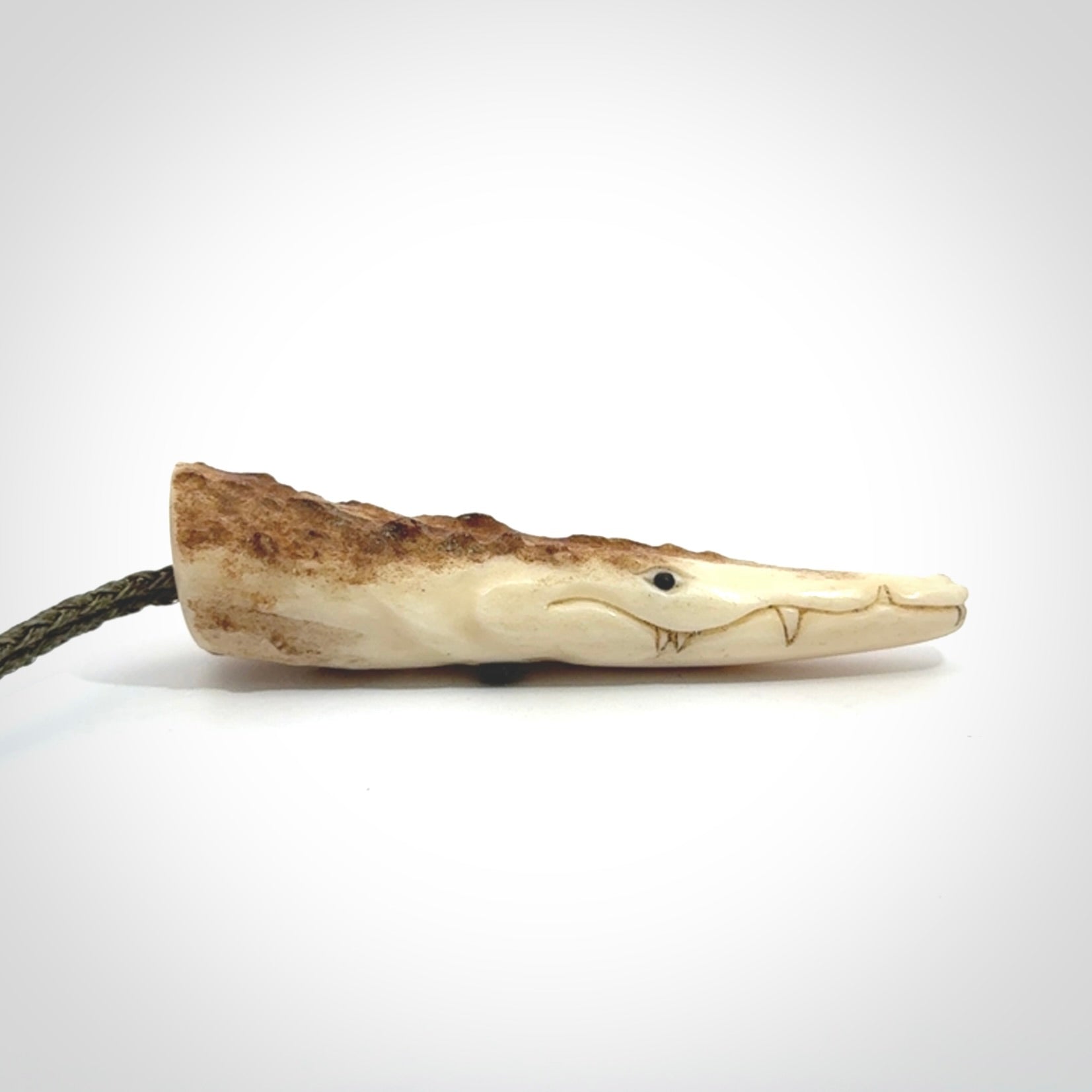 A hand carved crocodile pendant carved from a piece of deer antler. This is a work of art carved by Fumio Noguchi who is renowned for his skill in bone carving.