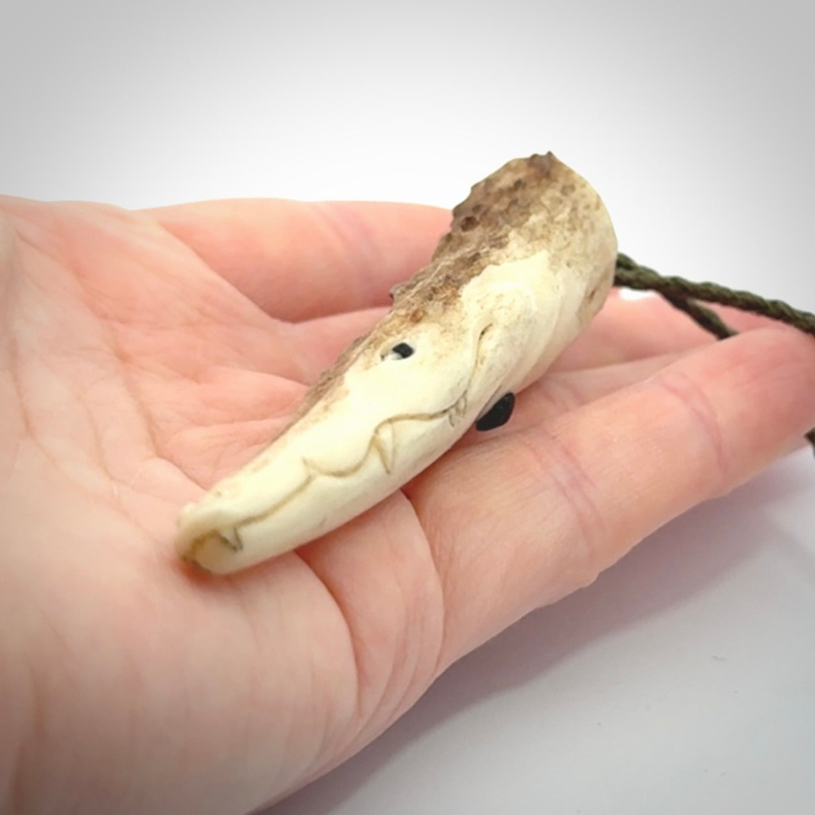 A hand carved crocodile pendant carved from a piece of deer antler. This is a work of art carved by Fumio Noguchi who is renowned for his skill in bone carving.
