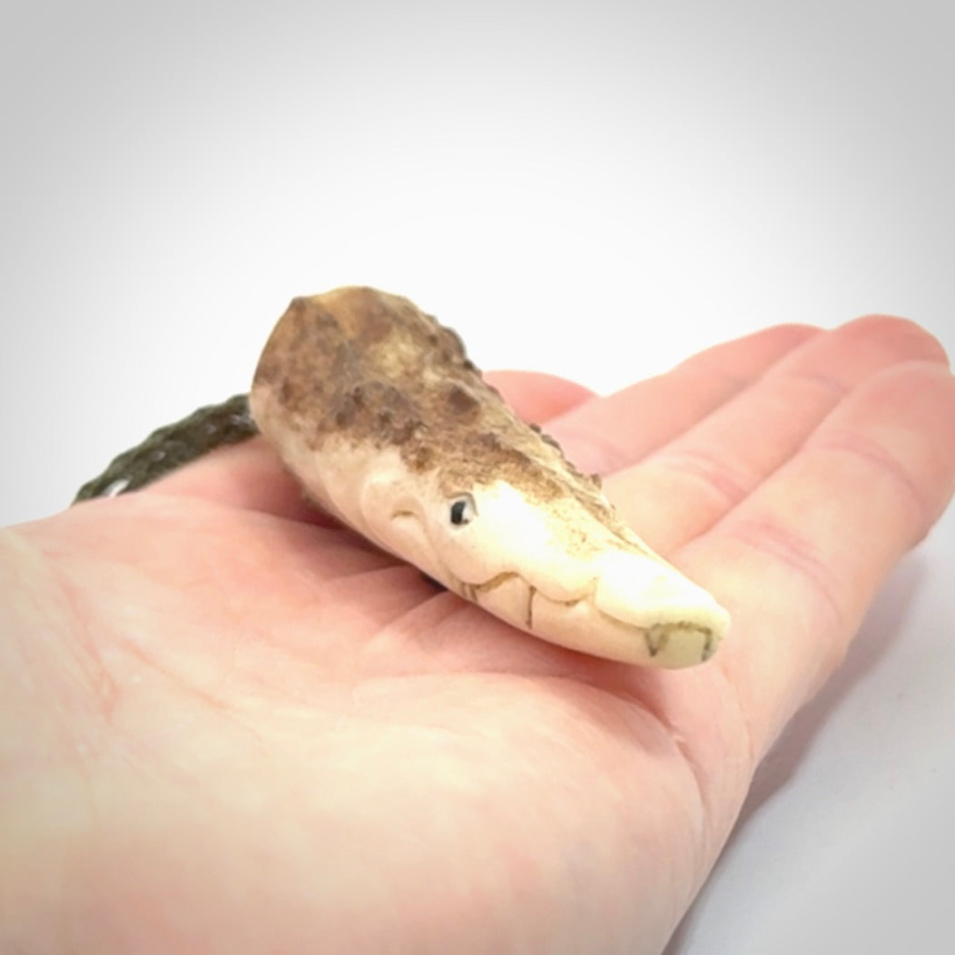 A hand carved crocodile pendant carved from a piece of deer antler. This is a work of art carved by Fumio Noguchi who is renowned for his skill in bone carving.