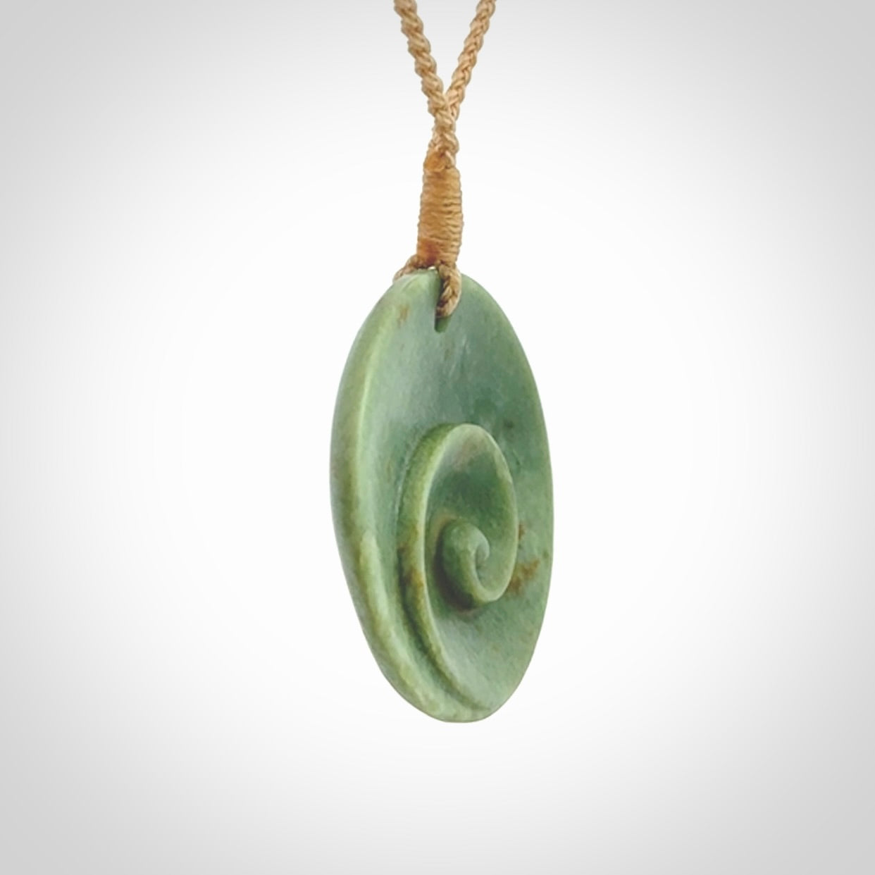 This pendant is a medium sized and cupped koru necklace carved from a lovely light green piece of New Zealand Marsden Jade.