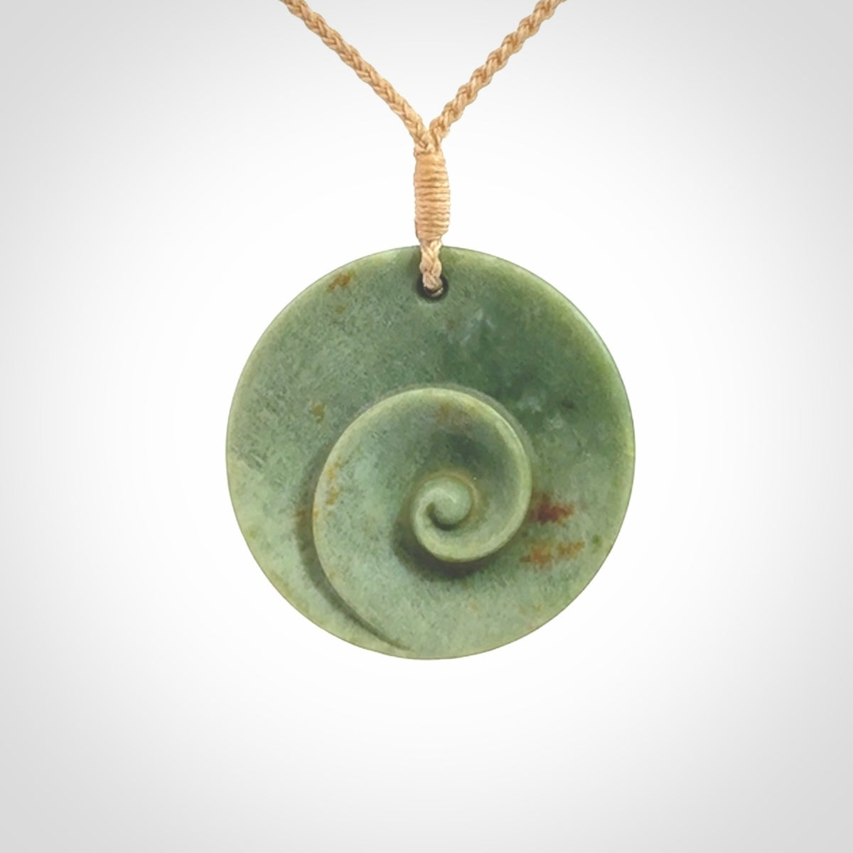This pendant is a medium sized and cupped koru necklace carved from a lovely light green piece of New Zealand Marsden Jade.