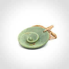 This pendant is a medium sized and cupped koru necklace carved from a lovely light green piece of New Zealand Marsden Jade.