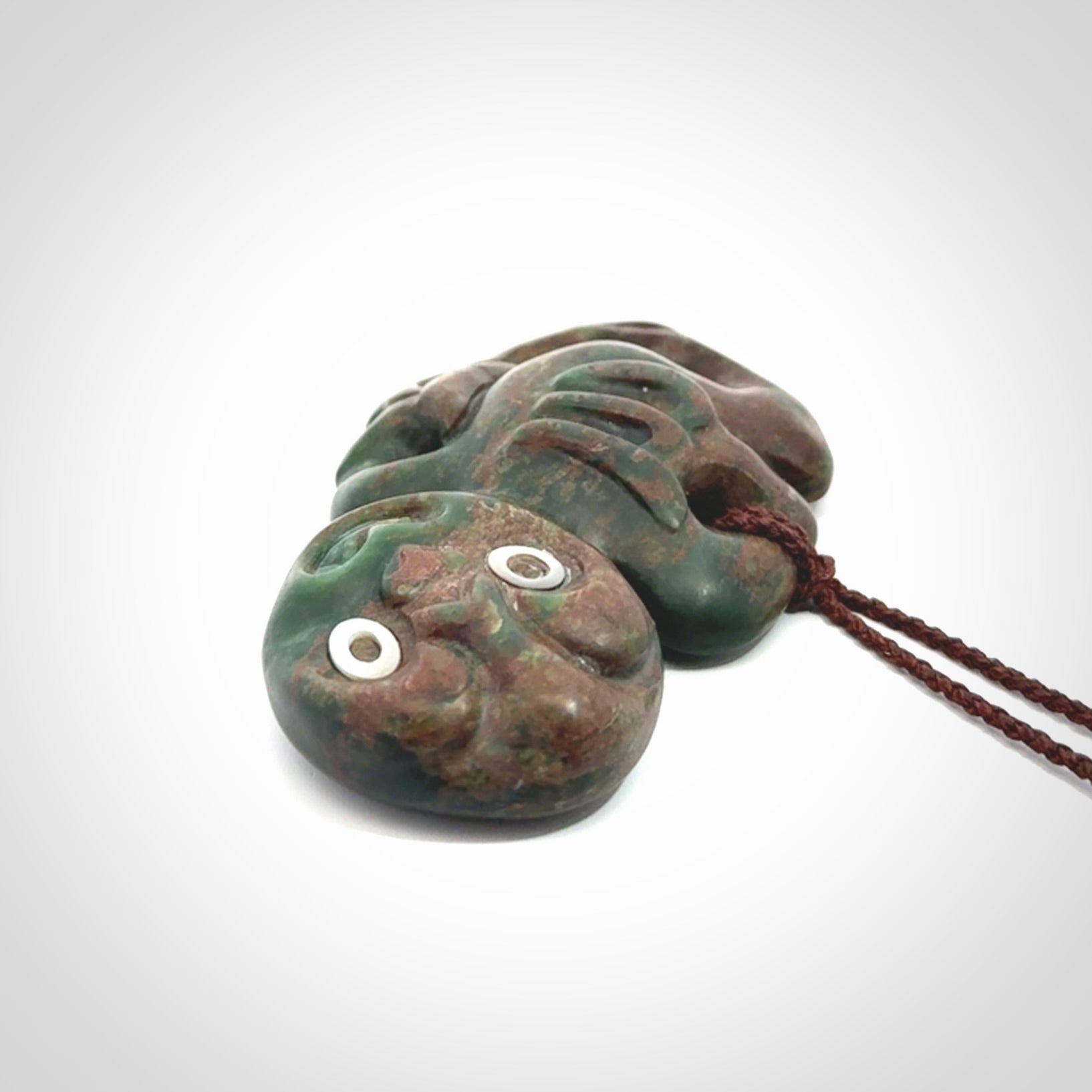 This is a large sized tiki - carved from gorgeous Marsden jade with Pāua Shell eyes. The craftsmanship is superb, this piece is as well carved as any we have seen. We have plaited an adjustable brown cord for this piece.&nbsp;